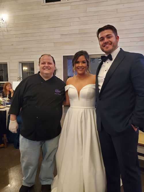 Chef Cody Hickman with a bride and groom at their wedding
