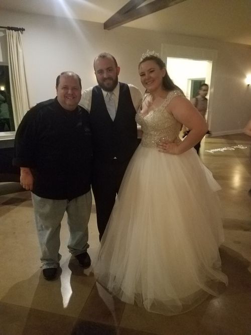 Chef Cody Hickman with a bride and groom at their reception