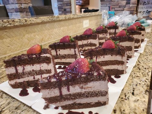 Slices of layered chocolate cake with strawberries on a platter
