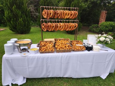 An outdoor pretzel bar and snack table set up by 360 Catering